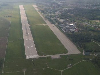 Letecký snímek Mezinárodního Letiště Pardubice. V rámci projektu by mělo dojít k rozšíření vnitřní infrastruktury a k výstavbě parkovacích míst (autor Avayak, Wikipedia).