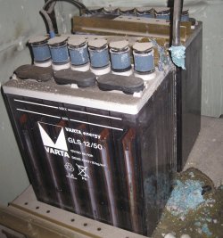 Dvojice trakčních olověných akumulátorů se zaplavenými deskami u kterých při špatném nabíjení vytekla část elektrolitu (foto: Wikimedia, Lead holder)