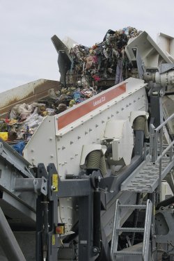 Podávací pás při transportu nadrceného odpadu k dvojici sít