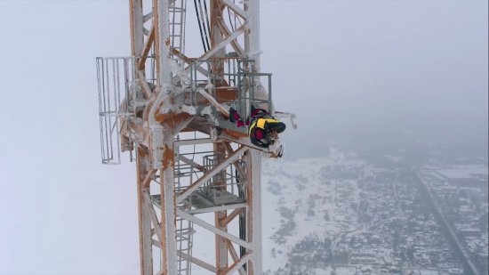 Ivan Dikun leží na úzké ocelové lávce ve výšce 430 m, aby zkontroloval senzor věžového otočného jeřábu