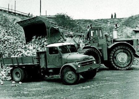 Jeden z prvních strojů u nás, kloubový kolový nakladač 988, se vyráběl od roku 1963. V té době se jednalo o největší nakladač Caterpillar, disponoval výkonem 325 koní a mohl být vybaven lopatou o objemu 6 kubických yardů (cca 4,5 m3)