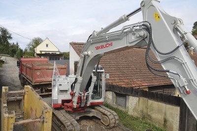 Typické pro největší Takeuchi TB2150 je masivní otočný kozlík na boku stroje (tzv. „Knickmatic“) nebo výložník se dvěma hydraulickými válci.