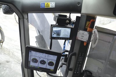 Epiroc SmartROC T40 má v kabině centrální ovládací monitor a nad ním monitor kamer. Na sloupku je vidět speciální náklonoměr.
