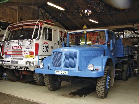 Modrá desetitunová třístranná sklápěčka Tatra 111 S2 (r. v. 1961) v roli pracovního stroje a soutěžní Tatra 815 posádky Loprais – Stachura – Kalina.