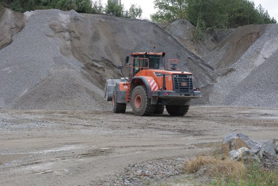 Kolový nakladač Doosan DL420 při manipulaci s kamenivem. Vysoký objem lopaty pomáhá zkrátit nakládku a snížit počet pracovních cyklů.