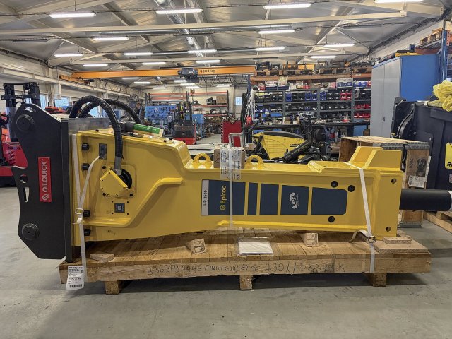Hydraulické kladivo Epiroc HB 2500 osazené automatickým rychloupínačem OilQuick. Těžká kladiva této řady jsou určena pro primární demolice, rozpojování hornin a náročné nasazení v lomech nebo při infrastrukturních stavbách. Charakteristická je robustní konstrukce, inteligentní ochranné systémy proti chodu naprázdno a možnost rychlé výměny příslušenství přímo z kabiny stroje bez zásahu obsluhy.